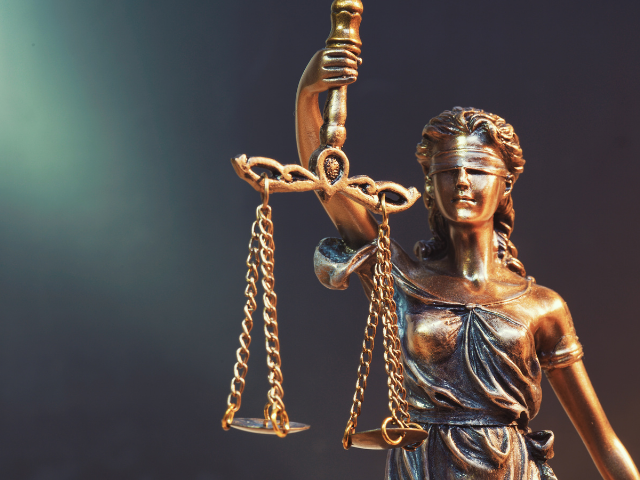 a bronze statue of a woman holding scales