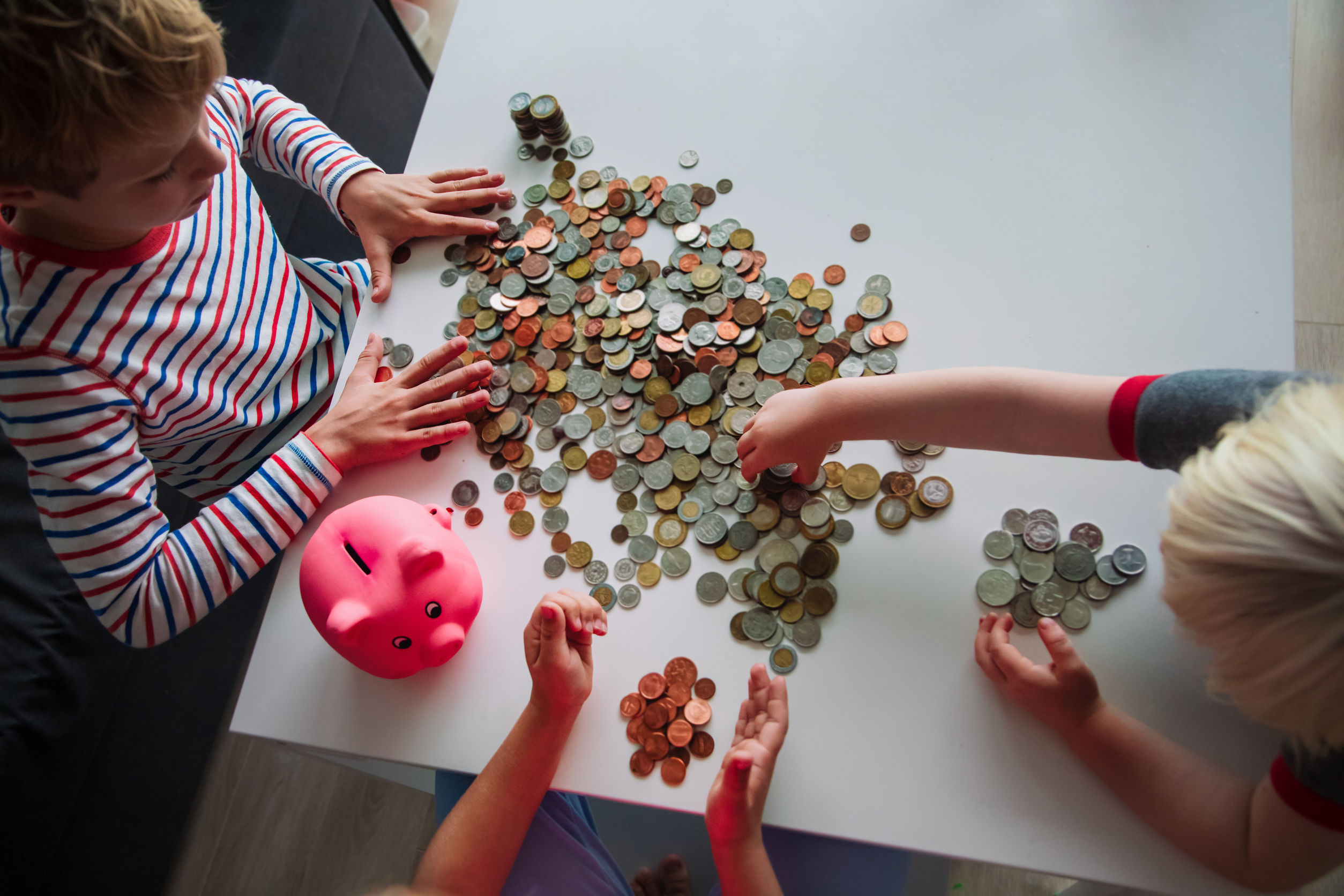 a birdseye view of children counting money from a piggy bank