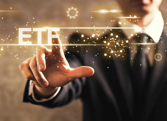 a man in a suit pointing to the word ETF