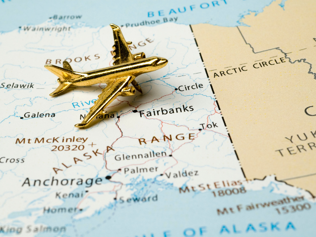 a map of the world with a gold plane figure on it