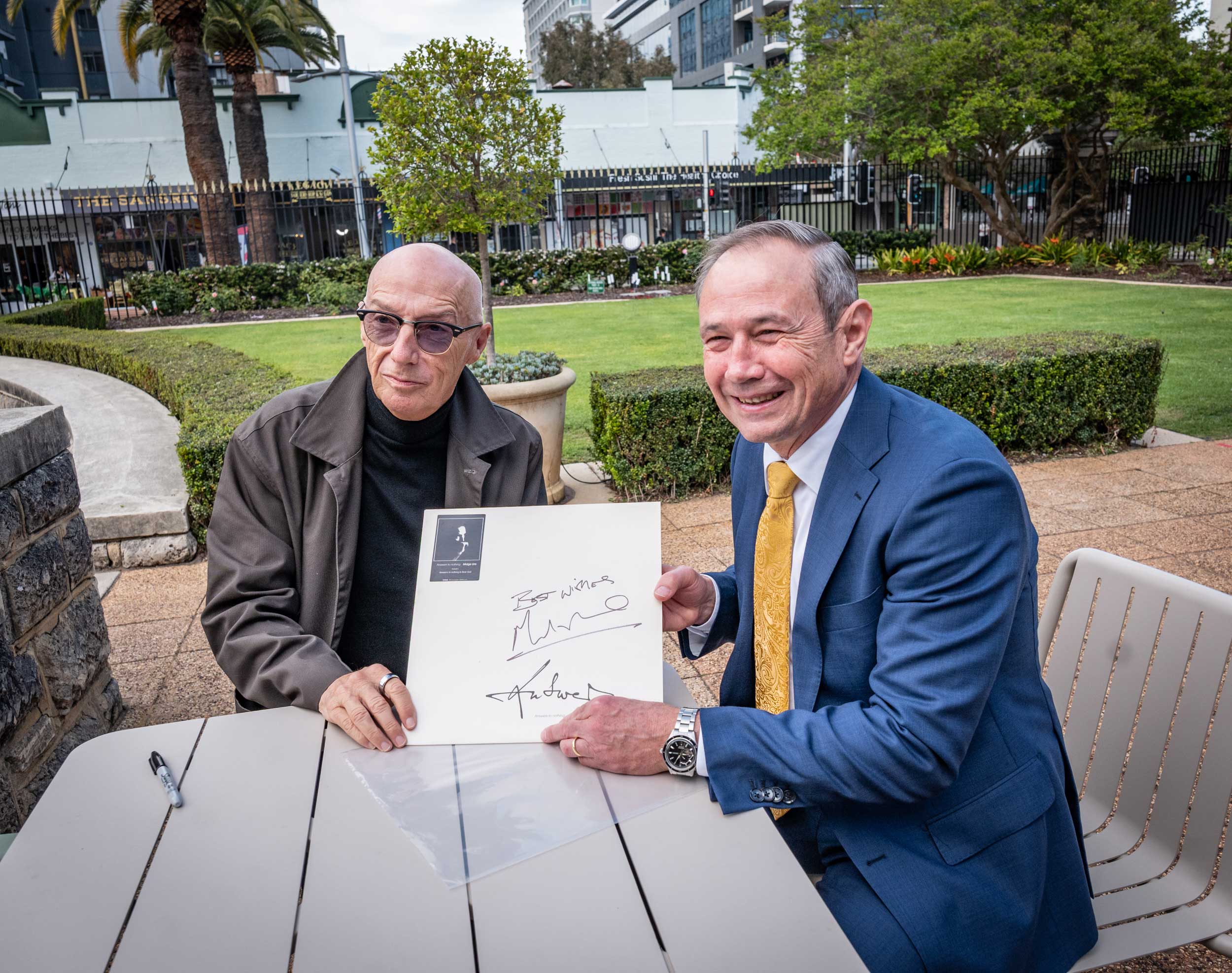 Midge Ure with Premier Roger Cook signing a vintage Midge Ure vinyl record.