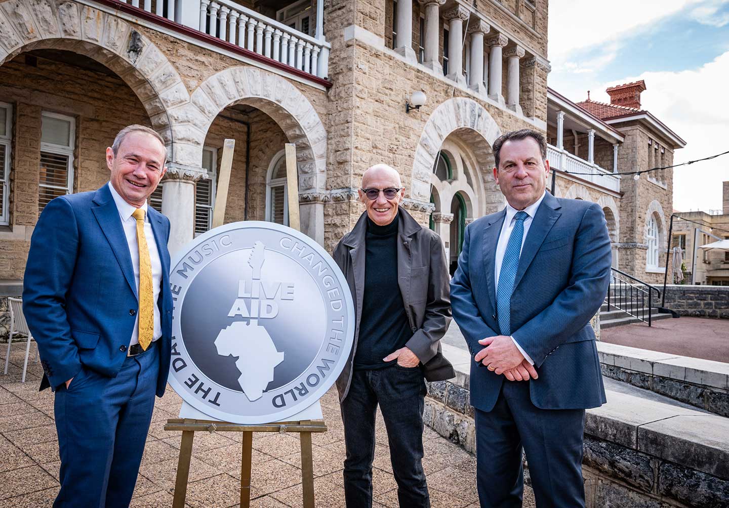 Perth Mint Chairman, John Van Der Wielen, musician Midge Ure and Premier Roger Cook in front of the Perth Mint