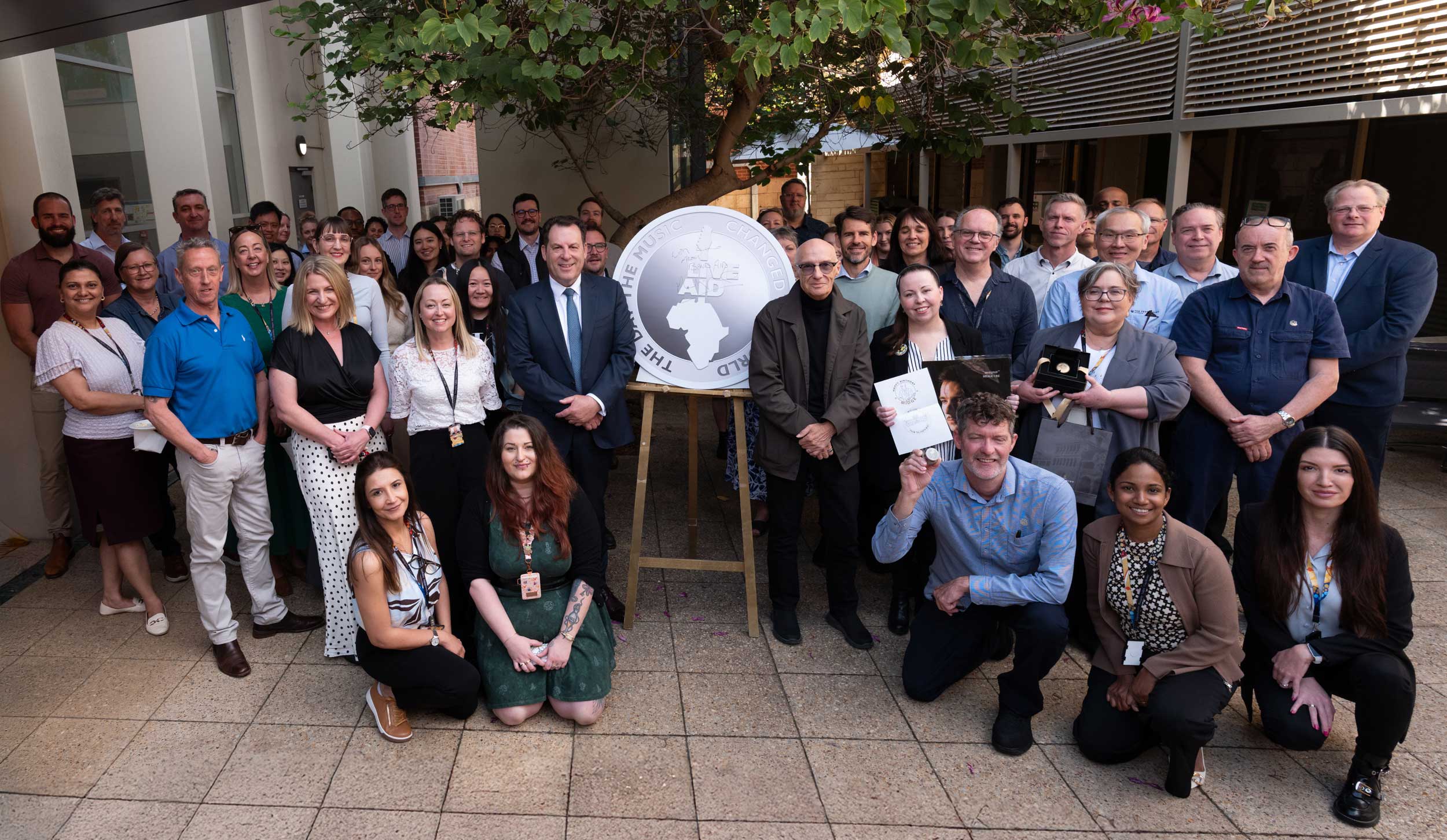 Musician Midge Ure, Perth Mint Chair John Van Der Wielen and Perth Mint staff in a group photo