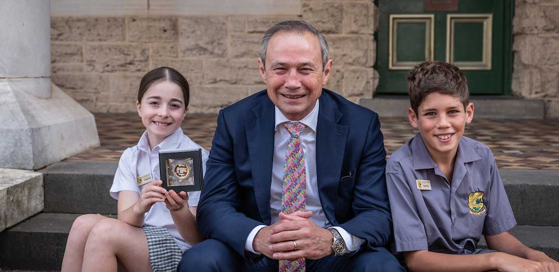WA Premier Roger Cook with two St Francis Xavier Primary school students and their Perth Mint Medallion