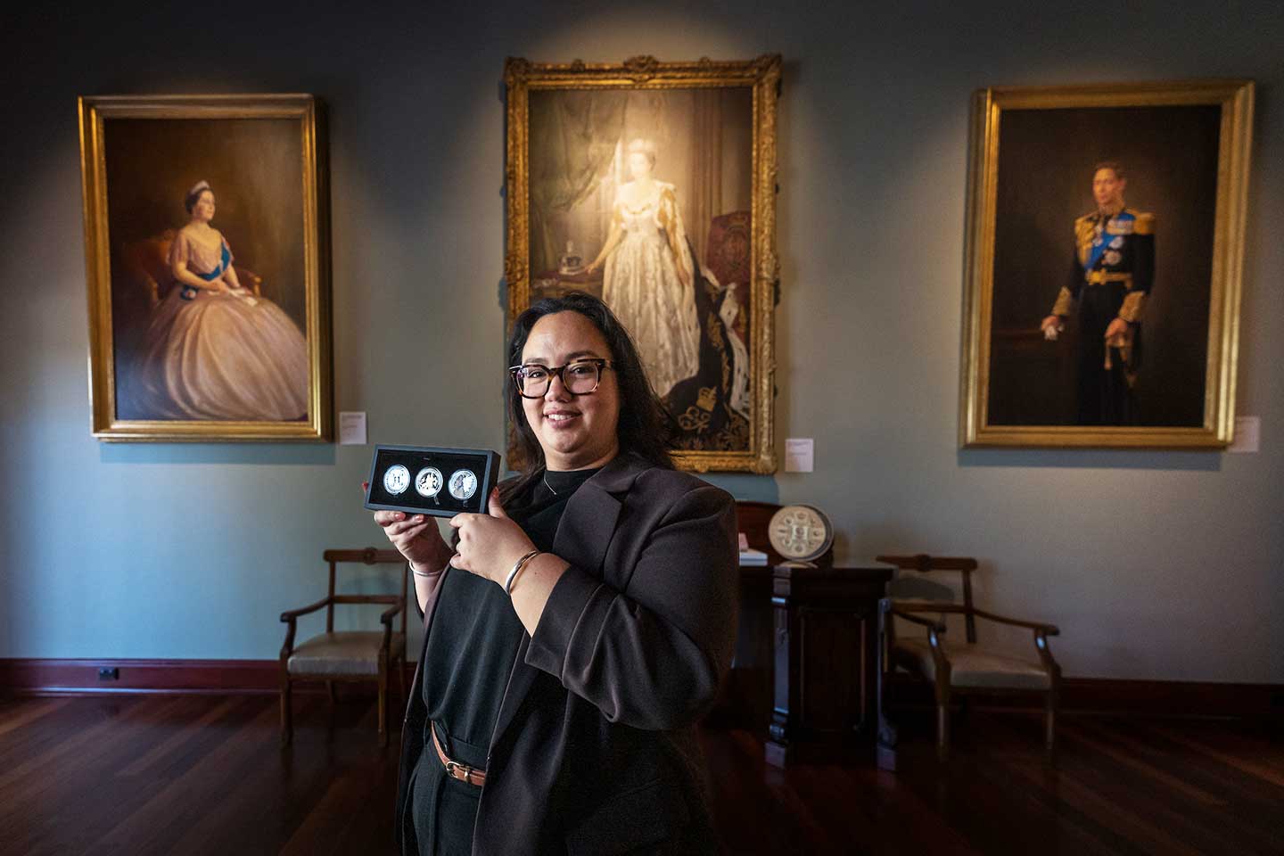 Perth Mint Designer, Natasha Muhl holding her coins of Queen Elizabeth II